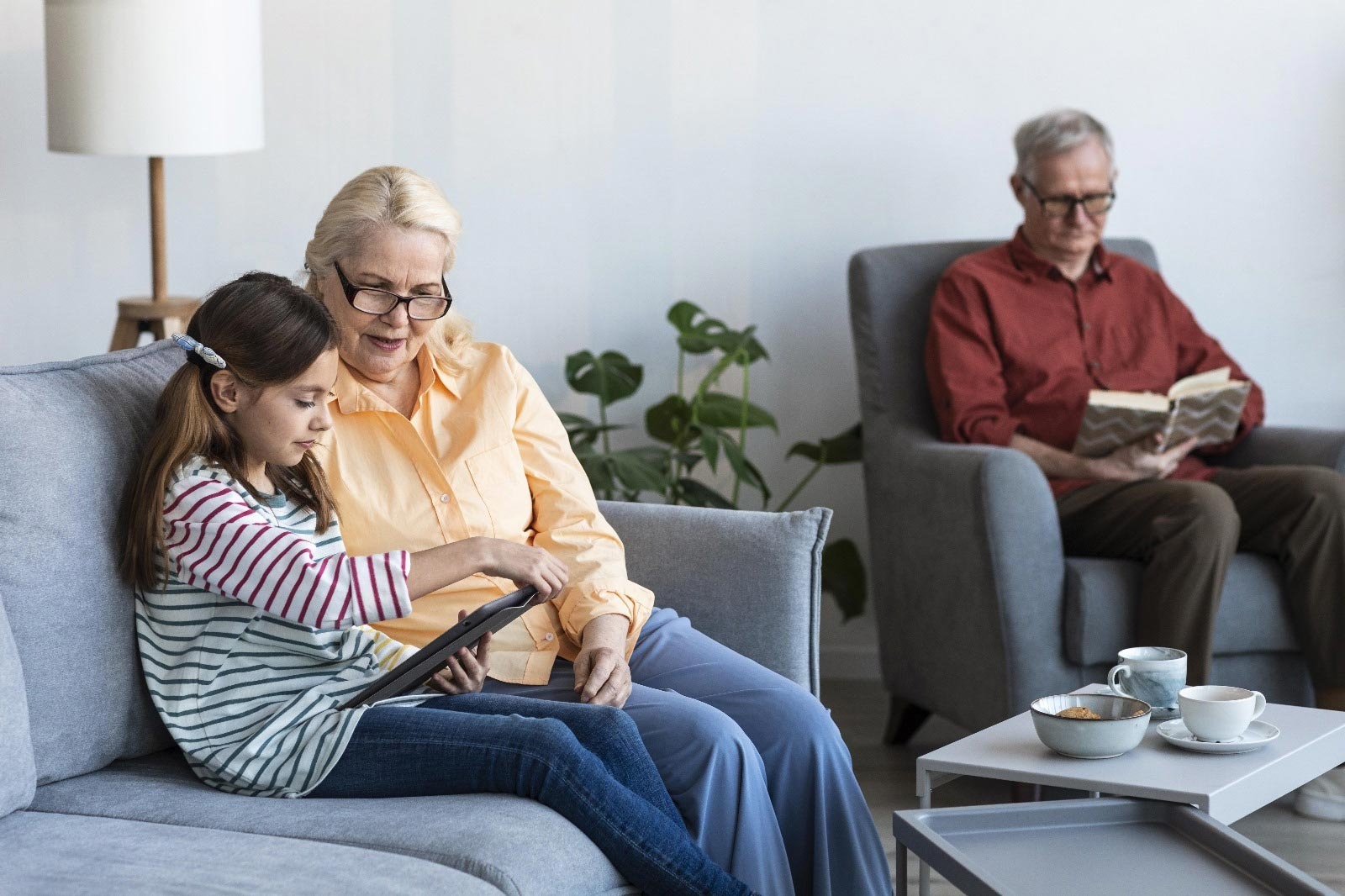 Grandparents read a book with young child